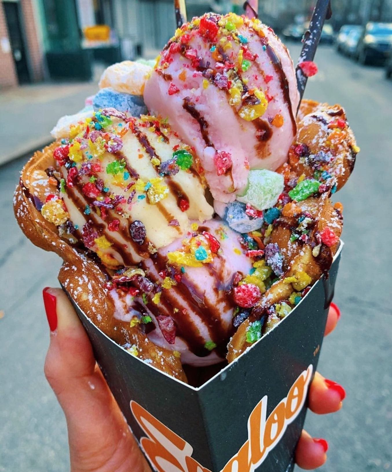Eggloo cone loaded with ice cream, chocolate drizzle, and Fruity Pebbles