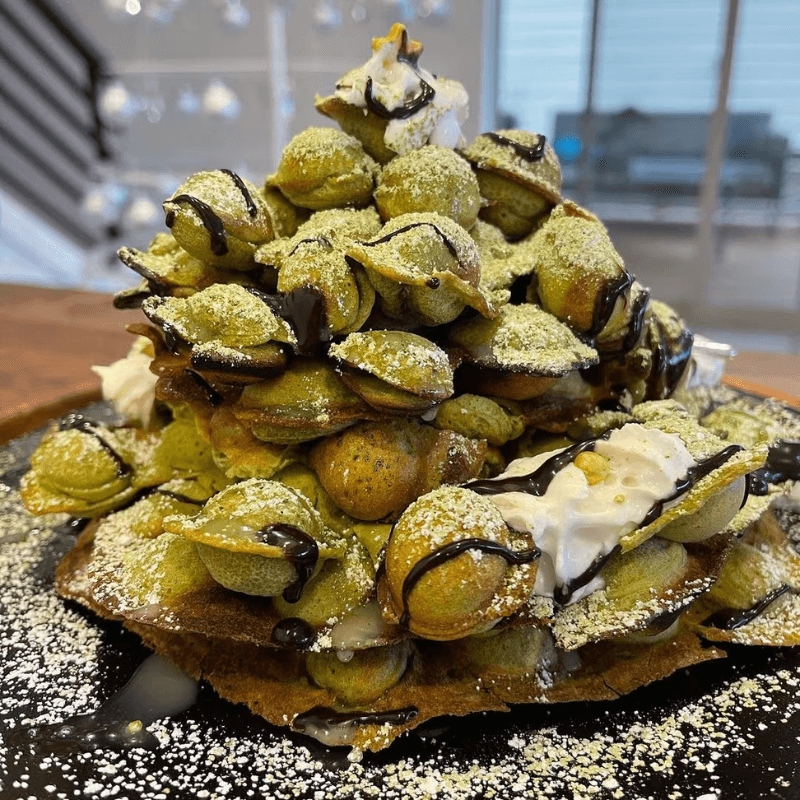 Matcha egg waffle tower with chocolate drizzle